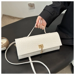 Détail du sac blanc à texture tissée avec fermoir doré et poignée élégante