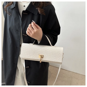 Détail du sac à main blanc texture crocodile avec fermoir doré et bandoulière