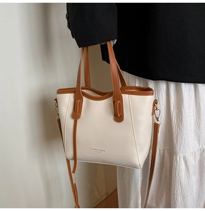 Detail of minimalist cream tote bag with brown straps and stylish letter printing