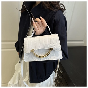 Détail du sac à bandoulière blanc motif crocodile avec chaîne dorée et rabat élégant