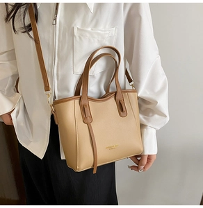 Dettaglio della borsa tote in pelle kaki con manici marrone scuro e logo stampato moda