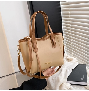 Dettaglio borsa tote a contrasto con scritte dorate e tracolla regolabile elegante