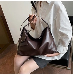 Detail der dunkelbraunen Hobo-Tasche aus Kunstleder mit kleinem Beutel und Schultergurt