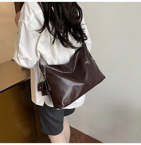 Detailansicht einer großen braunen Tote Bag mit passendem Mini-Beutel an einem Model