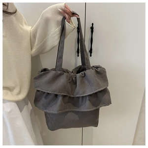 Detailansicht der dunkelgrauen Faltenrüschen und weißen Nähte an einer süßen Retro-Handtasche