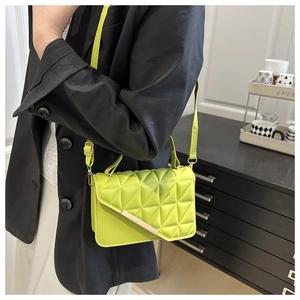 Detail of lime green quilted crossbody bag with gold metal trim and PU leather texture