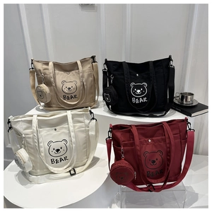 Detail of four colorful canvas tote bags with bear print and matching coin purses