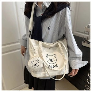 Close-up of white canvas tote bag featuring bear print and matching coin purse detail
