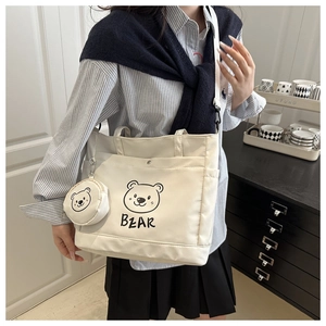 Detail of canvas tote bag featuring cartoon bear print and matching round coin purse