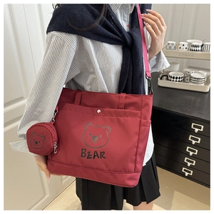 Detail of red canvas tote bag with bear print and matching round coin purse on a strap