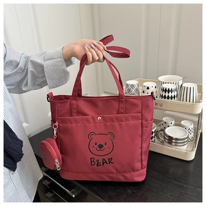 Detail of red cartoon bear tote bag with round pendant and sturdy double handles