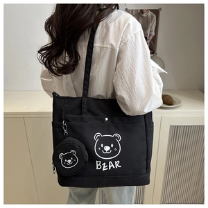 Detail of black tote bag with white bear print and matching small round charm pouch