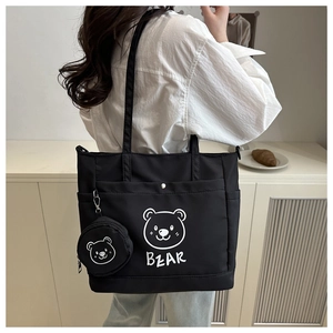 Detail of black tote bag with white cartoon bear print and small round coin purse