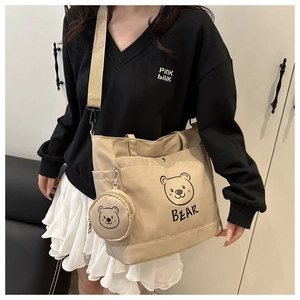 Detail of canvas tote bag featuring cute cartoon bear print and side storage pocket