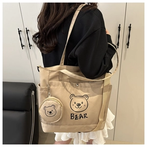 Detail of khaki tote bag with cartoon bear print and matching round mini pendant pouch