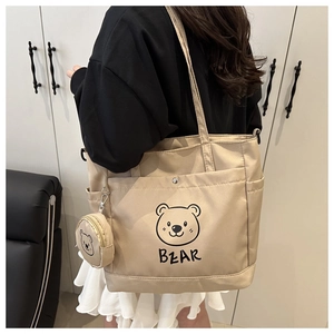 Detail of beige tote bag featuring cartoon bear print and a matching small round pouch