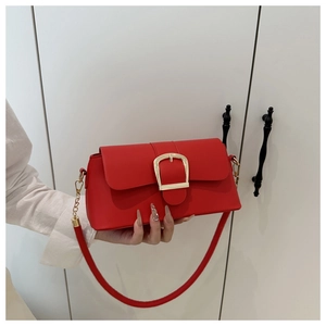 Detailed shot of red matte leather handbag with prominent gold square buckle hardware