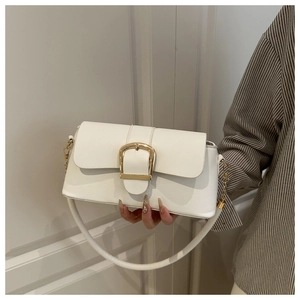 Detailed shot of cream white leather bag with a large gold buckle and metal chain strap
