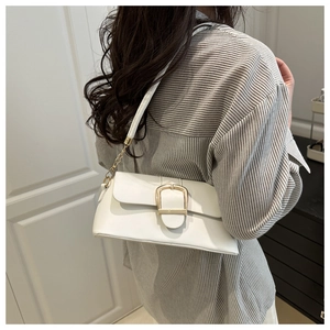 Modern white leather crossbody bag with a large gold buckle and metal chain strap