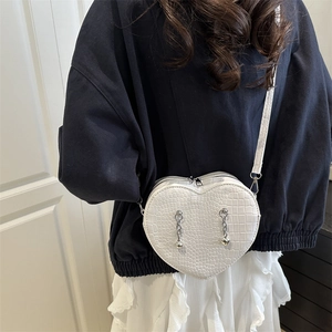 White heart-shaped crossbody bag with crocodile texture and silver chain detail