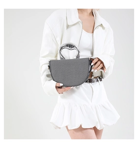 Detail of grey saddle bag featuring a unique silver metallic avant-garde handle design