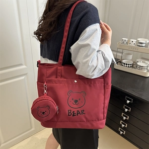 Burgundy tote bag with cartoon bear print and matching round coin purse on shoulder