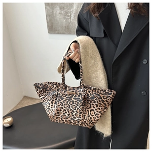Detail of leopard print tote bag with gold metal plate and premium faux leather texture