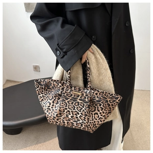 Detail of trendy leopard print tote bag with dual handles and metal buckle decoration