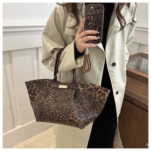 Close-up of leopard print tote bag featuring a gold emblem and spacious trapezoid design