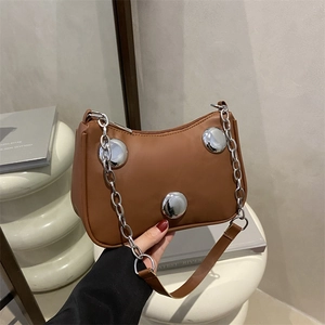 Brown leather underarm bag with bold silver metal studs and chunky chain strap