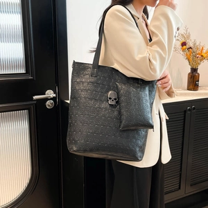 Black gothic skull embossed large tote bag with matching pouch on beige suit model
