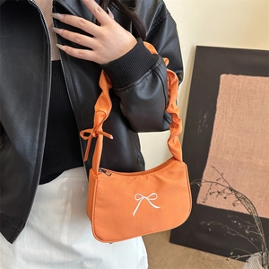 Orange shoulder bag with bow embroidery and scrunchie strap for a trendy look