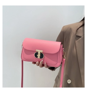 Gros plan du petit sac bandoulière rose vif avec fermoir métallique moderne en T