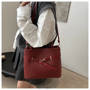 Dettaglio borsa tote bordeaux in pelle intrecciata con fibbia metallica dorata