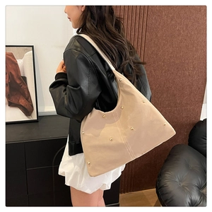 Detailed view of beige hobo bag with soft leather texture and golden stud accents