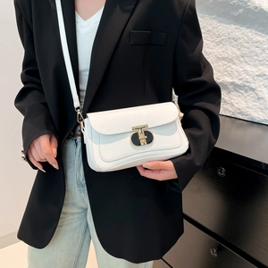 Sac bandoulière blanc tendance avec fermoir en T doré, porté par un mannequin chic