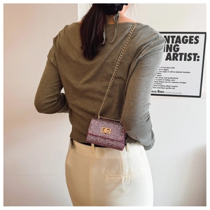 Vue détaillée d'un mini sac à paillettes avec bandoulière chaîne dorée porté par un mannequin