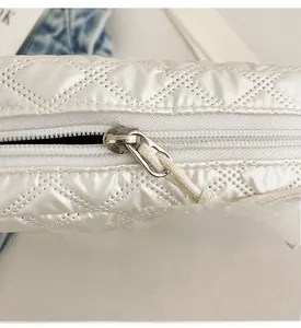 Détail du zip argenté avec cordon de serrage sur le sac bandoulière blanc matelassé