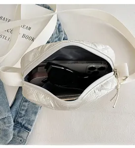 Vue intérieure d'un sac bandoulière blanc matelassé avec rangement pour téléphone et lunettes