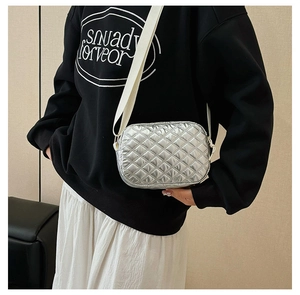 Détail du sac bandoulière argenté matelassé avec finition métallisée et large bandoulière