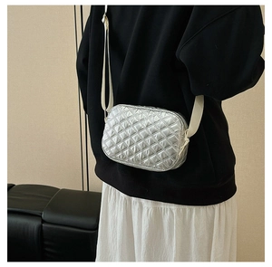 Détail du sac bandoulière argenté matelassé avec bandoulière en tissu réglable