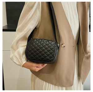 Détail du sac bandoulière matelassé noir avec motif losanges et large bandoulière en tissu