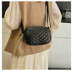 Sac bandoulière noir à motif matelassé losange avec bandoulière réglable sur un mannequin