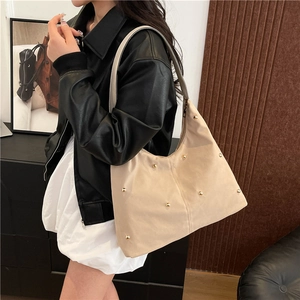 Beige oversized hobo shoulder bag with gold metal rivet studs and sleek zip closure