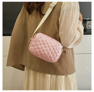 Vue détaillée du sac bandoulière en nylon rose matelassé avec large sangle réglable
