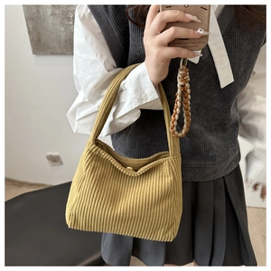 Detail of mustard yellow corduroy tote bag featuring vertical texture and magnet closure