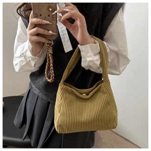 Detail of green corduroy tote bag with bead trim and gold magnetic buckle closure