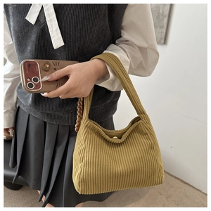 Close-up of mustard yellow corduroy shoulder bag with vertical ribbed texture and snap closure