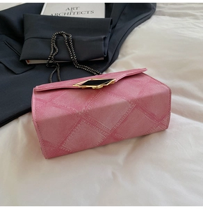 Detail of pink quilted denim texture shoulder bag with gold hardware and chain strap