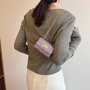 Mini sac bandoulière chic à paillettes violettes avec chaîne dorée sur mannequin